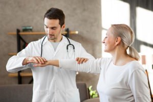 Paciente recibiendo atención médica y fisioterapia para enfermedades reumáticas.