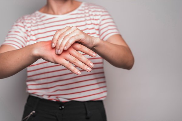 Persona con dolor articular considerando si tiene una enfermedad reumática.